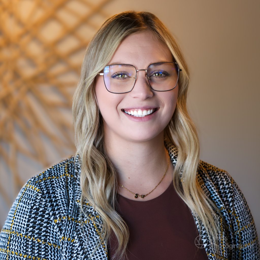 Professional corporate headshot of a woman with glasses in an Edmonton office.